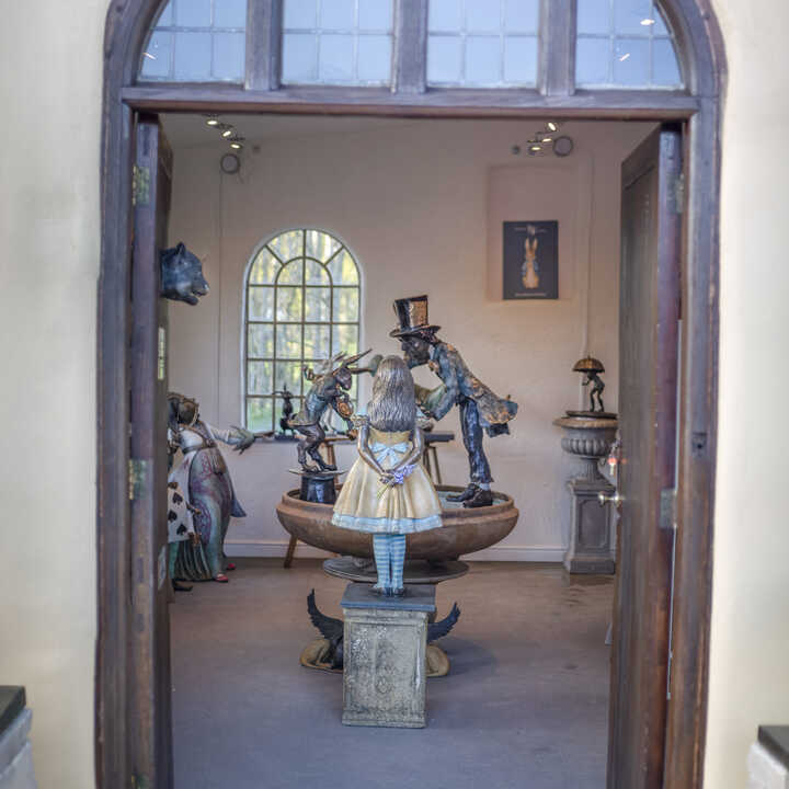 Looking through the doors at the Robert James Workshop Gallery; with Alice, the Tea Party Urn and the Queen of Hearts visible.