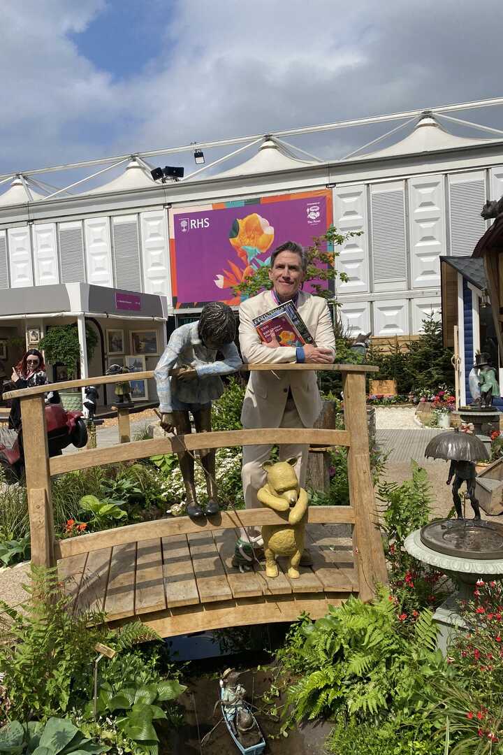 Comedian Rob Brydon stands at the Poohsticks Bridge garden water feature at RHS Chelsea Flower Show 2025