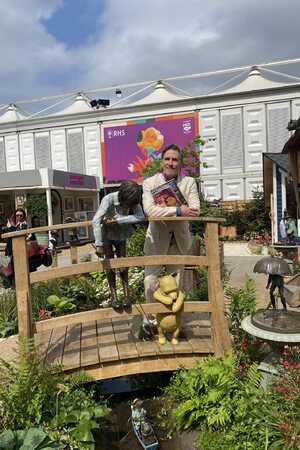 Comedian Rob Brydon stands at the Poohsticks Bridge garden water feature at RHS Chelsea Flower Show 2025