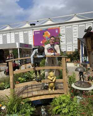 Rob Brydon standing on the Poohsticks Bridge at RHS Chelsea Flower Show 2025