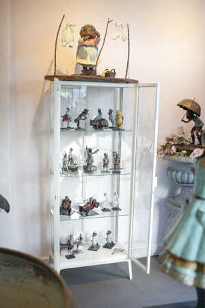 display case of miniature bronze sculptures including winnie the pooh, toad of toad hall and dodo