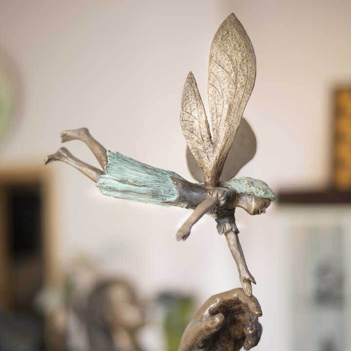 Tinker Bell landing on Peter Pan's hand, part of the Garden Sculpture by J.M. Barrie's original story