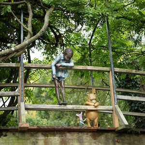 Winnie the Pooh, Piglet, and Christopher Robin, look over the Poohsticks Bridge - A garden sculpture from Robert James Workshop