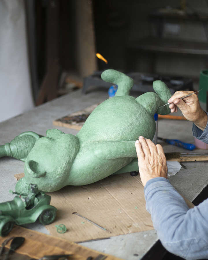 Close-up of wax detailing of Winnie the Pooh garden sculpture being worked on